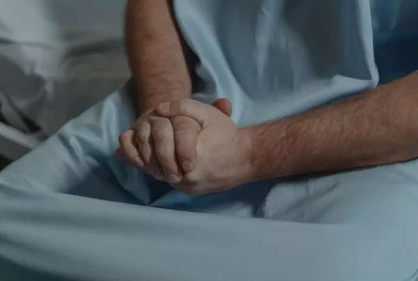 Foto primer plano de una persona vetida como enfermero sosteniendose las manos